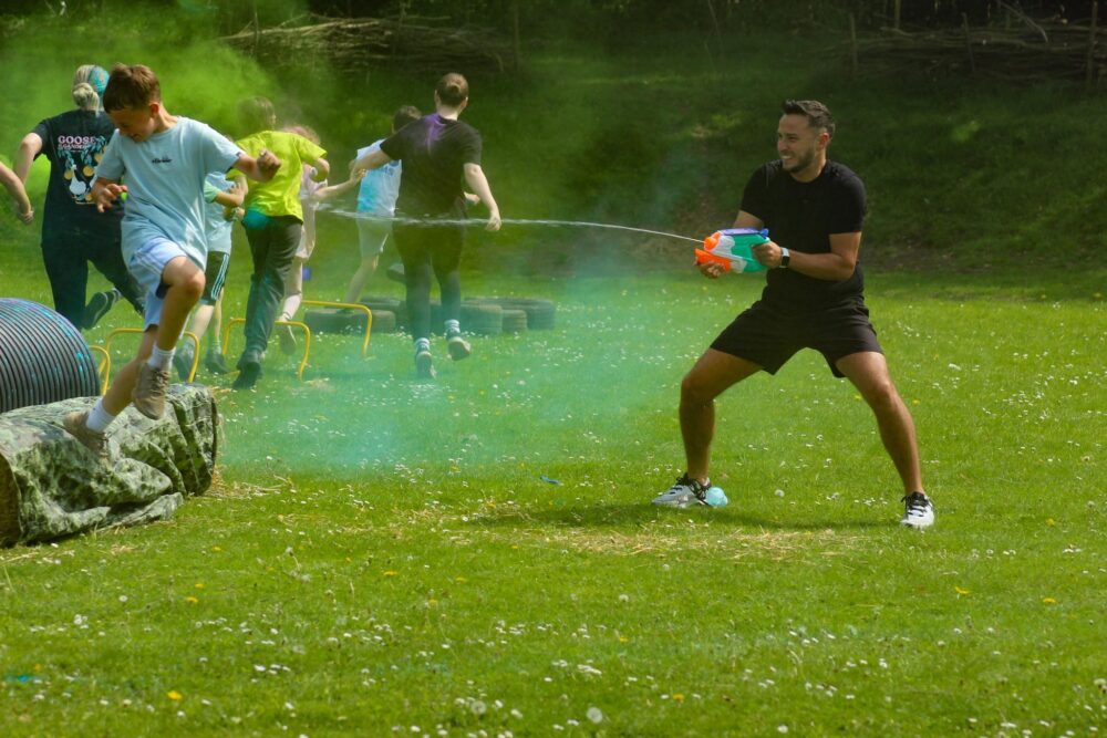 teacher sprays the pupils with colour