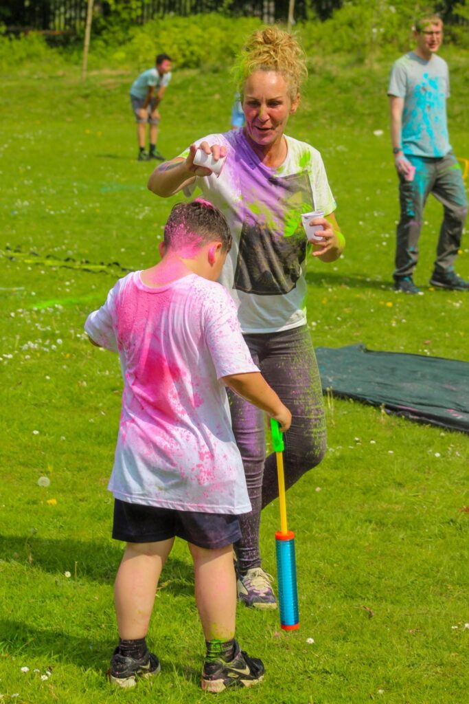 staff and pupil covered in pink colour powder
