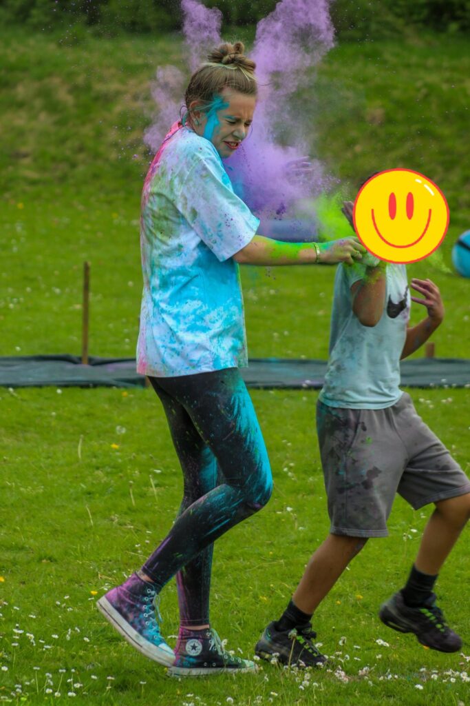 pupil and teacher covered in colour powder